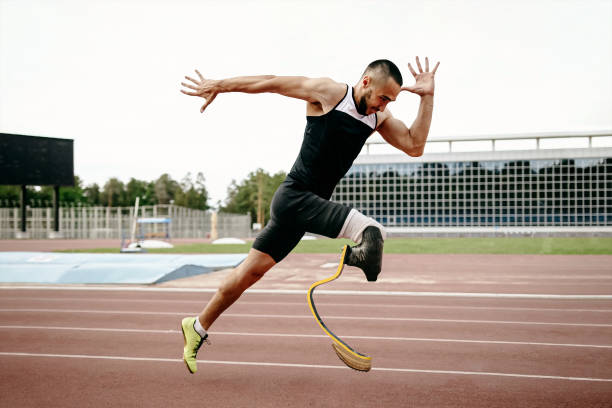 disabled male runner on prosthetic leg on track of stadium